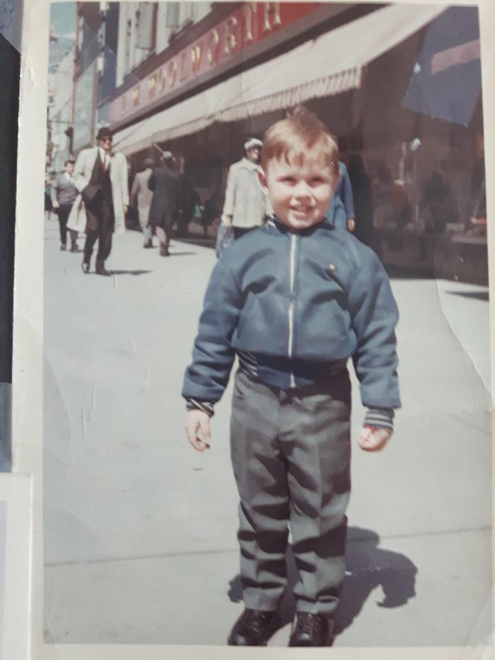 6 year old Stephen Barker smiling on a busy street.